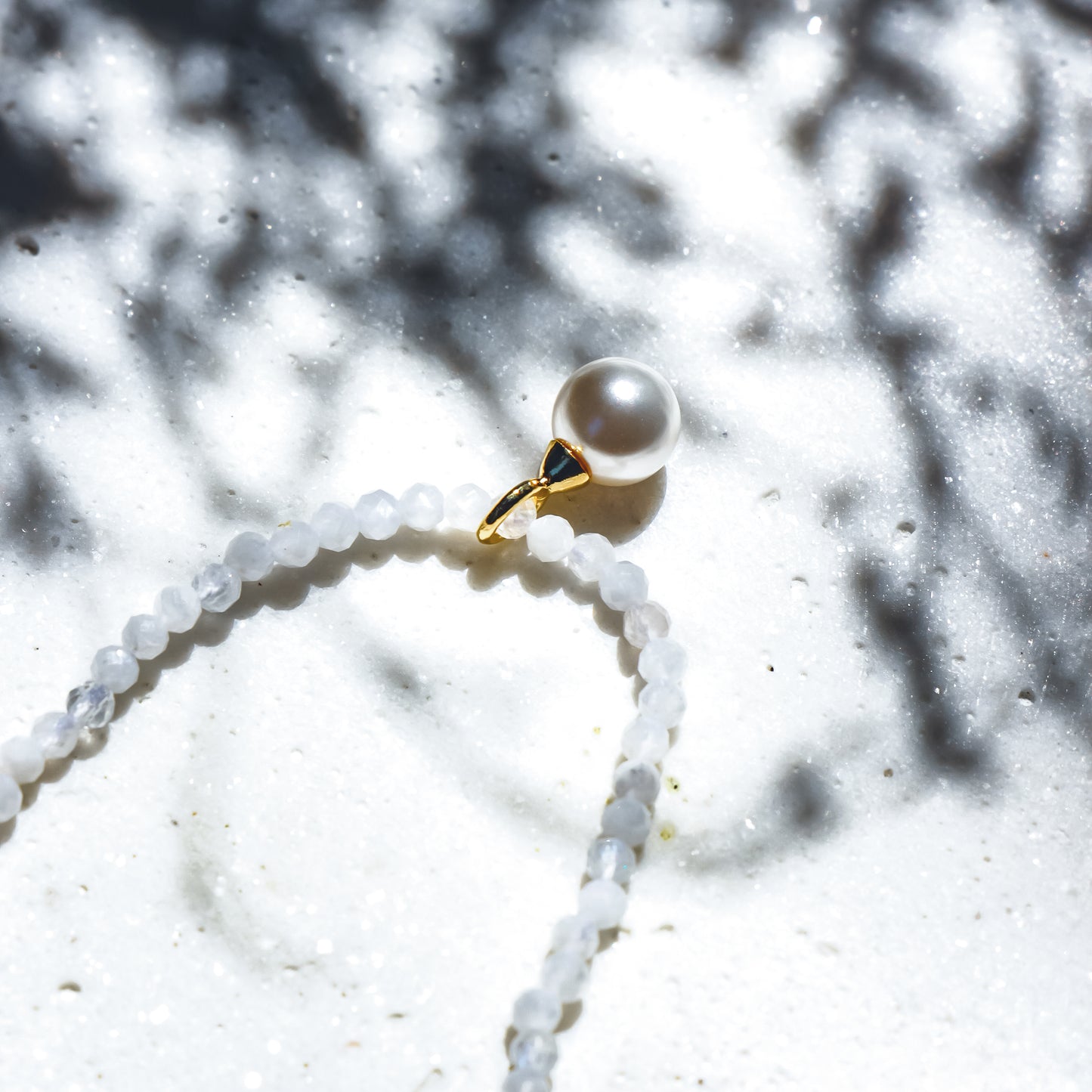 Pearl necklace with white stone on a white background